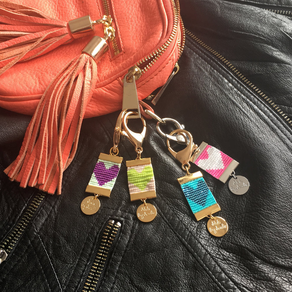 Colorful Charmed Heart Bag Charms - Handwoven with Gold Accents 
Discover the perfect spring accessory! These handwoven Charmed Heart bag charms come in various colors and feature 24 carat gold plated clamps and a chunky gold clasp Bijou Her